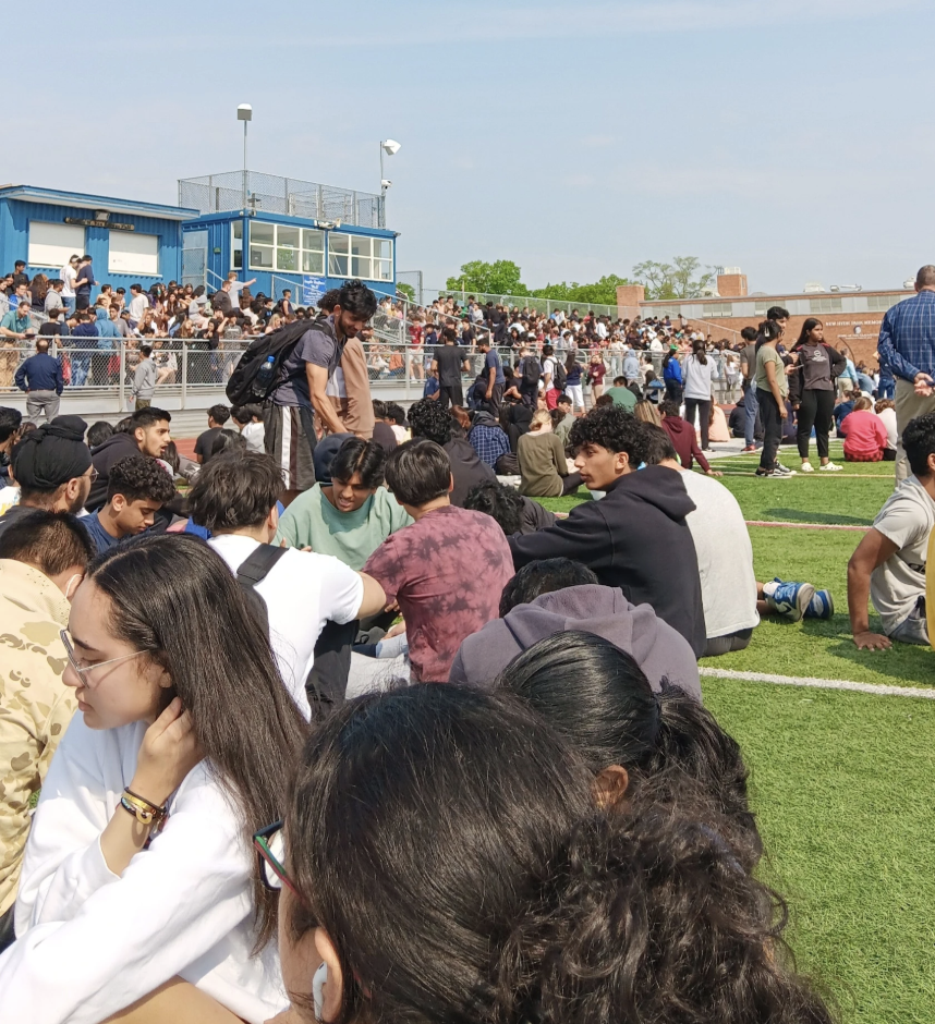 Students gather on the football field and in the bleachers outside of NHP while the swat situation is assessed.